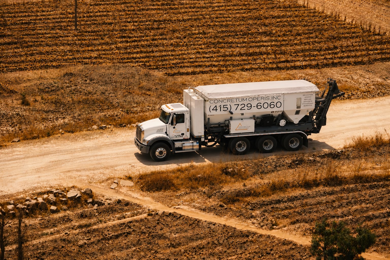 Aerial view of a Concretum Operis mixer truck on a rural road